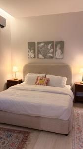 a bedroom with a large white bed with two lamps at August in Jazan