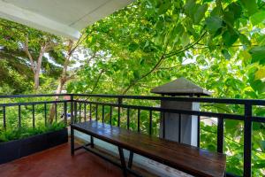 a wooden bench on a balcony with a tree at Kata Station Boutique Hotel, Kata Beach in Kata Beach +33 photos