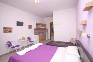 a bedroom with a bed and a table and chairs at Sklavos Studios skopelos in Neo Klima
