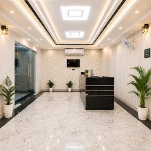 an office lobby with a reception desk and potted plants at Hotel Lotus Infinity in Haridwār