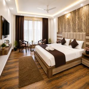 a bedroom with a large bed and a television at Hotel Lotus Infinity in Haridwār +34 photos
