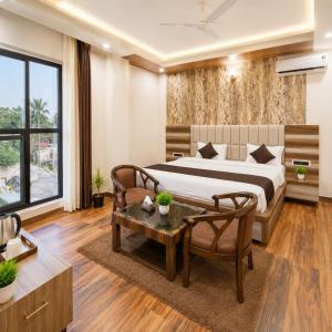 a bedroom with a bed and a table at Hotel Lotus Infinity in Haridwār