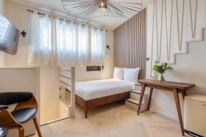 a small bedroom with a bunk bed and a table at Studios - Appartements Le Médicis in Rouen