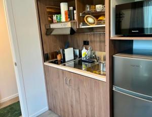 a small kitchen with a sink and a refrigerator at Oasis in onerahi in Whangarei