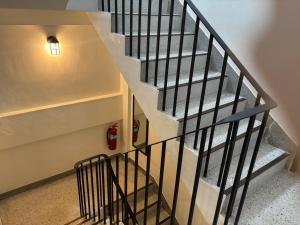 a staircase with black railings and a fire extinguisher at Laloon Guesthouse in Hat Yai