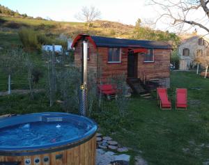 a hot tub in front of a tiny house at La roulotte de la croix in Entrepierres +12 photos