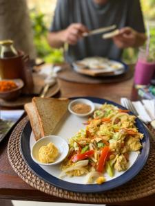a table with a plate of food on a table at Nirwa Ubud Karma in Ubud