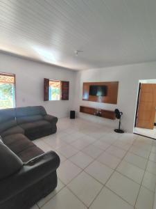 a living room with a couch and a tv at Vila Azul Casa Completa em Ibicoara in Ibicoara