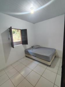 a bedroom with a bed in a room with a window at Vila Azul Casa Completa em Ibicoara in Ibicoara