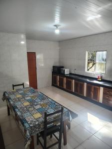 a room with a table and a kitchen with a counter at Vila Azul Casa Completa em Ibicoara in Ibicoara
