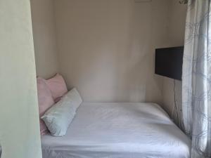 a small bedroom with a bed with white sheets and pillows at Refresh & Recharge 721 in Durban
