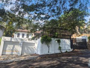 a white house with a gate and a white fence at Refresh & Recharge 721 in Durban