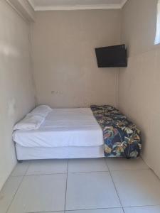 a small bed in a room with a tv on the wall at Refresh & Recharge 721 in Durban