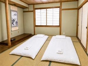 two beds in a room with a window at 響-Garden House- in Toyonaka