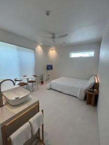 a bedroom with a bed and a sink and a table at 까사뚜아 Casa Tua in Sokcho