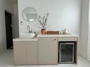 a white bathroom with a sink and a mirror at 까사뚜아 Casa Tua in Sokcho