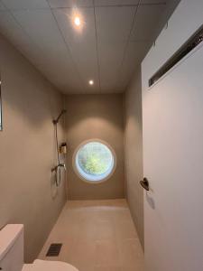 a bathroom with a round window in the ceiling at 까사뚜아 Casa Tua in Sokcho
