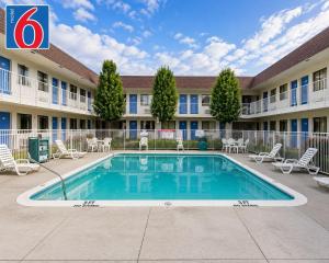 a hotel with a swimming pool in front of a building at Motel 6-Yreka, CA in Yreka