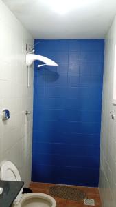a blue door in a bathroom with a toilet at Apartamento central bem localizado in Pelotas +13 photos