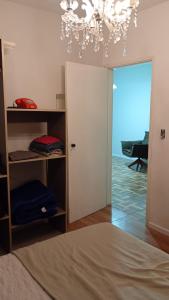 a room with a bed and a chandelier at Apartamento central bem localizado in Pelotas