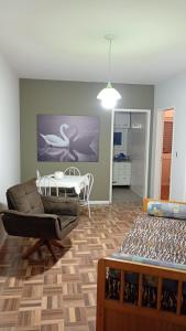 a living room with a table and a chair at Apartamento central bem localizado in Pelotas