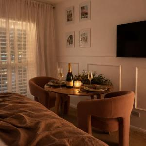 a dining room with a table with wine bottles and chairs at Luxury Renovated Resort Studio Apartment - Oaks Pacific Blue in Salamander Bay