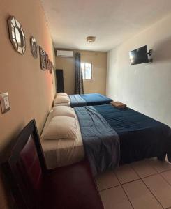 a hotel room with two beds and a tv at Hotel Peccato Originale in Tuxtla Gutiérrez