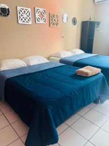two beds in a hotel room with blue sheets at Hotel Peccato Originale in Tuxtla Gutiérrez +15 photos