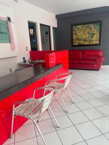 a living room with a red counter and two chairs at Hotel Peccato Originale in Tuxtla Gutiérrez