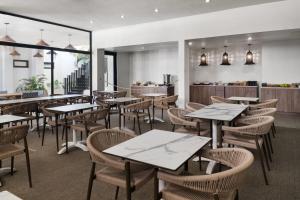 a restaurant with tables and chairs and a counter at Bali Hotel Adults Only Isla Verde, a Trademark by Wyndham in San Juan