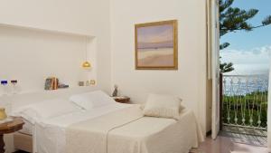 a white room with a bed and a window at Romantic Hotel & Restaurant Villa Cheta Elite in Maratea