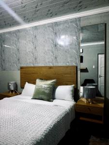 a bedroom with a large bed and a mirror at Mukomani Guesthouse in Soshanguve