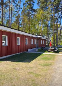 a red building with a picnic table in front of it at Bromölla Camping o Vandrarhem in Bromölla