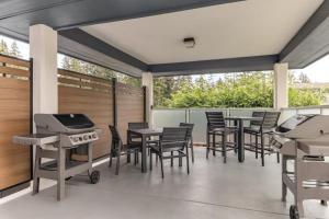 a patio with tables and chairs and a grill at Candlewood Suites Oak Harbor by IHG in Oak Harbor