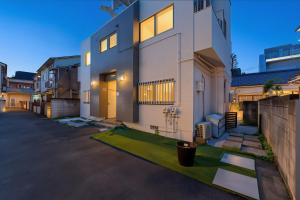 a large white house with a lawn in front of it at JUJO Inn in Tokyo