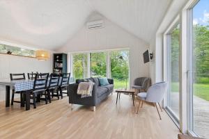 a living room with a couch and a table and chairs at 8574-Grenaa-Annavej-13 in Gjerrild