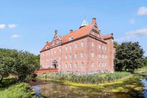 a large red brick building next to a river at 8574-Grenaa-Annavej-13 in Gjerrild