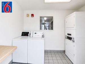 a kitchen with white cabinets and a laptop on a counter at Motel 6-Yreka, CA in Yreka