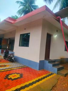 a house with a motorcycle parked in front of it at Manjunatha nilaya sute delux ordinary room in Kollūru +6 photos