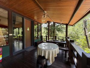 a porch of a house with a table and benches at 木木杉民宿 in Puli