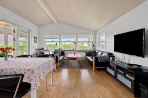 a living room with a table and a flat screen tv at FY421-Frorup-Grantoften-3 in Frørup