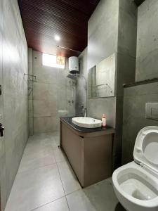 a bathroom with a sink and a toilet at Nagarkoti Residency Inn in Pithorāgarh +11 photos