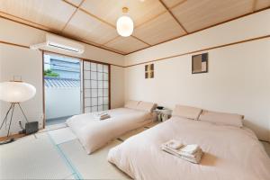 a bedroom with two beds and a window at JUJO Inn in Tokyo