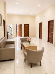 a living room with couches and a table and flowers at Solota Boutique Hotel Syariah in Bonorejo