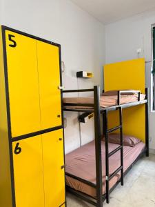 a room with two bunk beds and a yellow door at The Desire Delhi in New Delhi