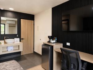 a kitchen with black walls and a black refrigerator at Sereno Business Inn in Ensenada