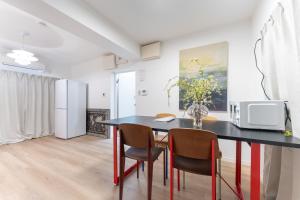 a kitchen with a table with chairs and a microwave at JUJO Inn in Tokyo