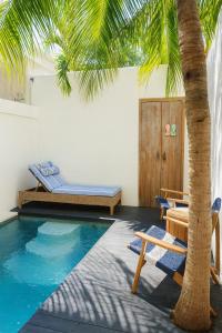 a swimming pool with chairs and a palm tree at Eve Evy Private Pool Villas in Nusa Lembongan
