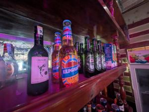a row of bottles of beer sitting on a bar at New Africa one inn in Dar es Salaam +5 photos