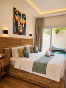a bedroom with a large bed with a painting on the wall at Eve Evy Private Pool Villas in Nusa Lembongan
